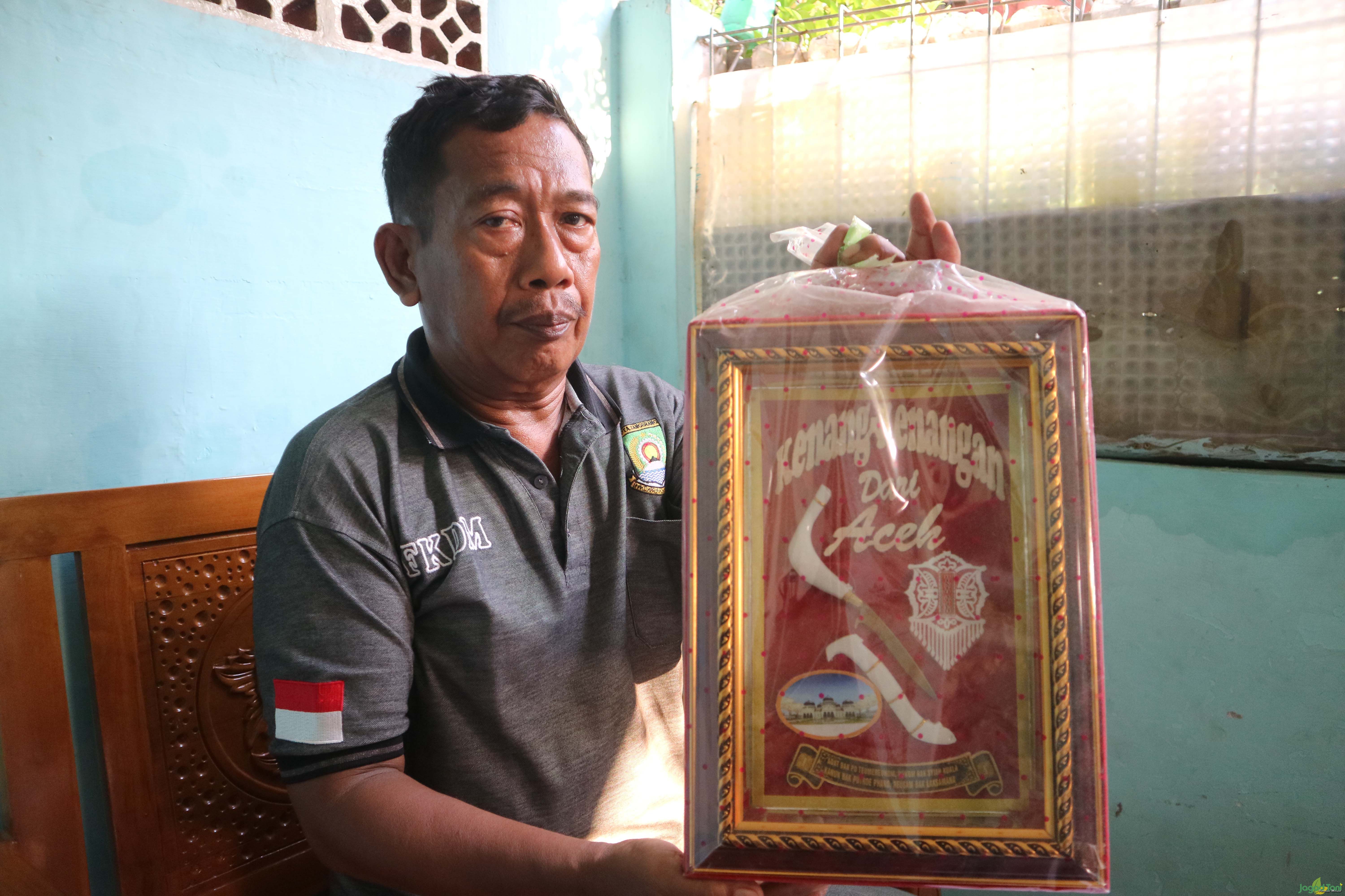 Kepala RW menunjukkan kenangan dari kunjungan warga Aceh